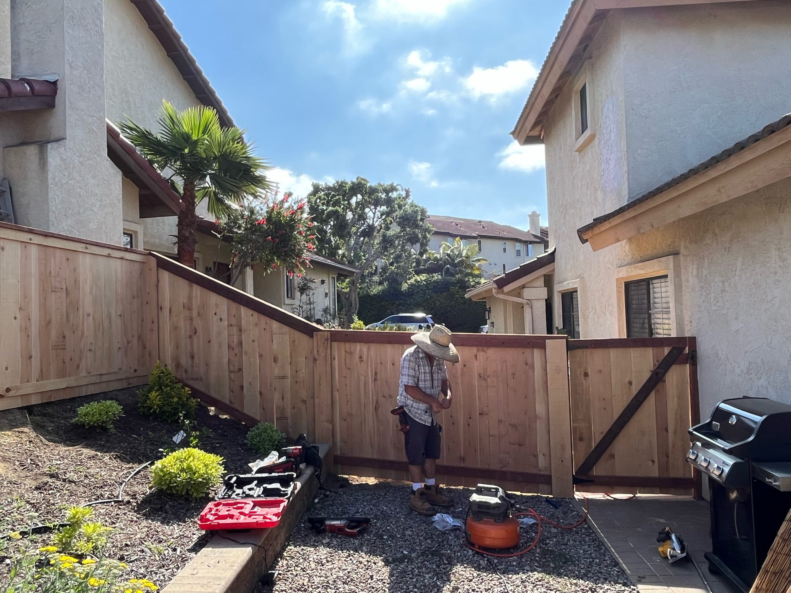 Fence installer doing fence repair and maintenance on a 6 foot wooden fence.